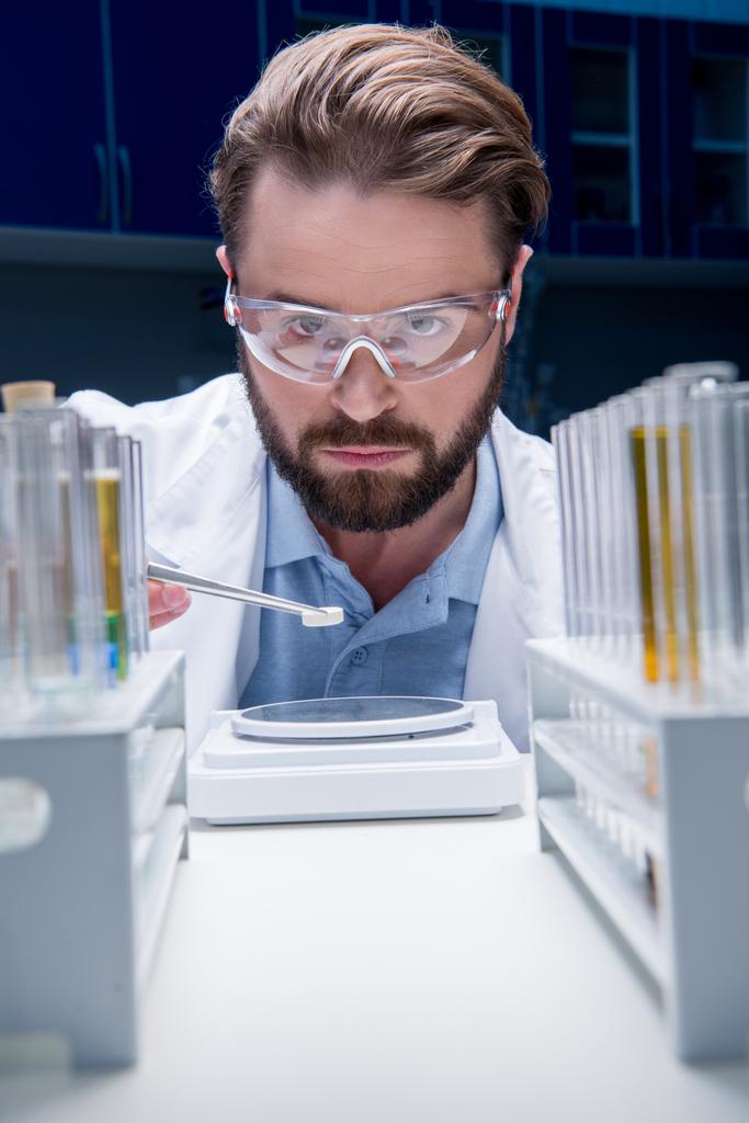 chemist in goggles with reagents - Photo, Image