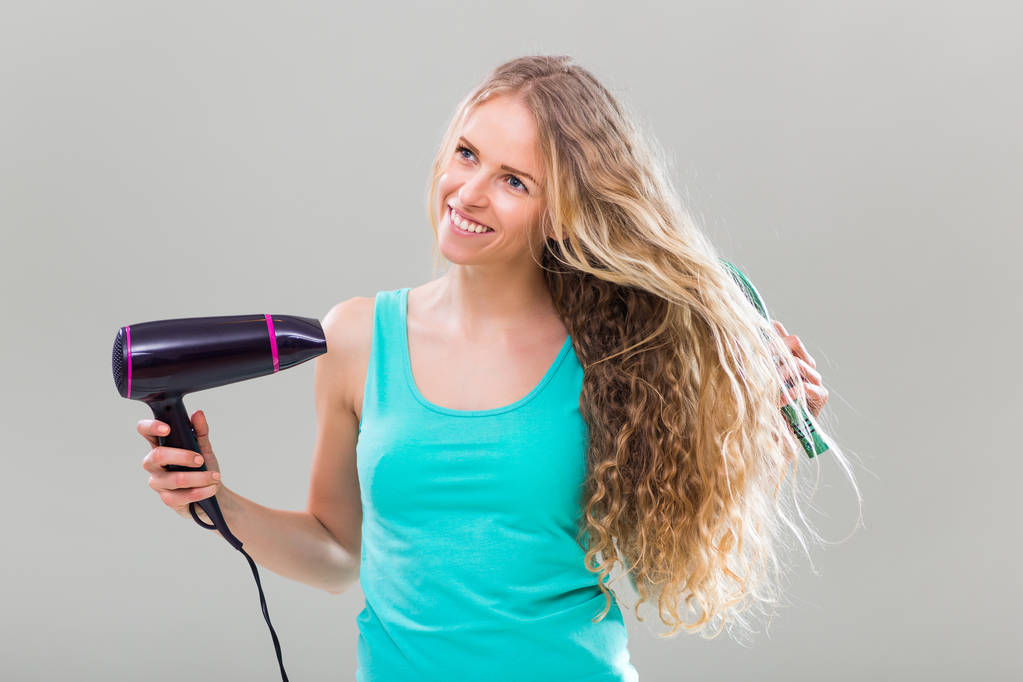 Frau benutzt Haarbürste und Haartrockner - Foto, Bild