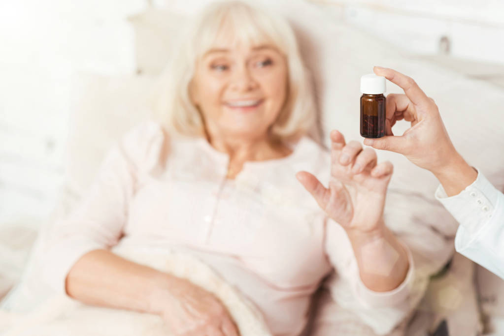 Onnellinen ikäinen nainen saa pillereitä sairaalassa
 - Valokuva, kuva