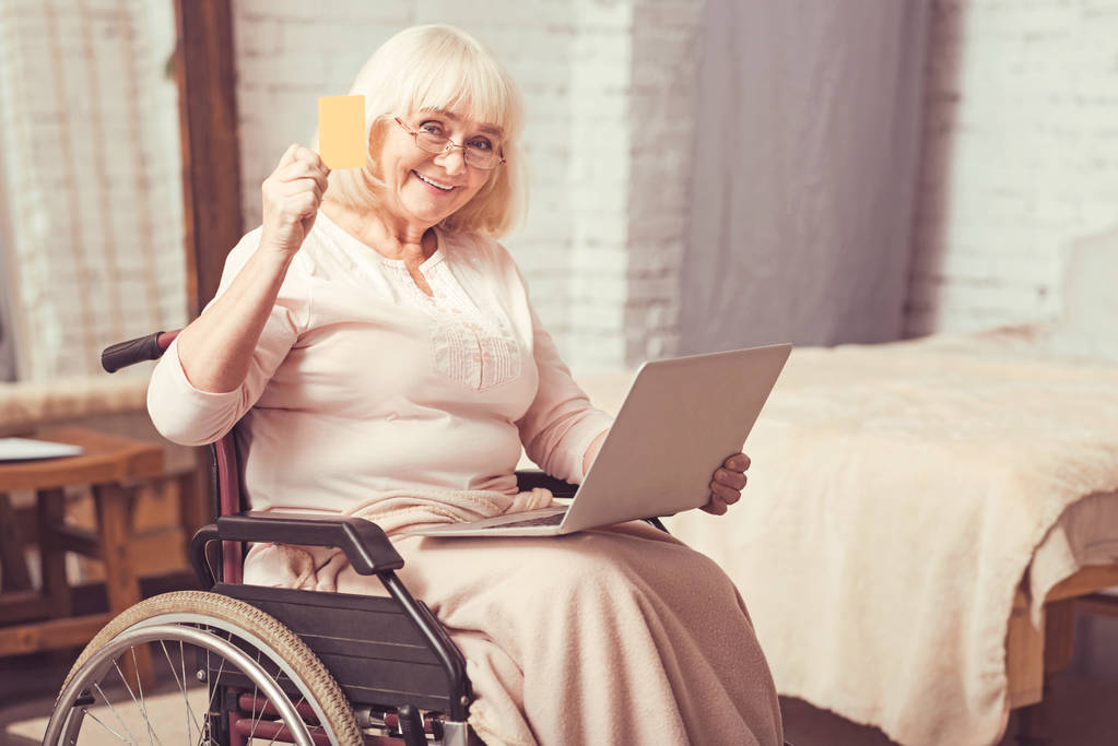 Invecchiato signora disabili utilizzando gadget moderno a casa
 - Foto, immagini