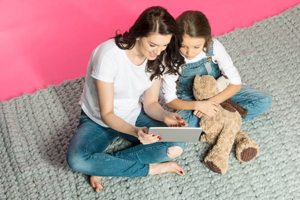Äiti ja tytär käyttävät digitaalista tablettia
  - Valokuva, kuva