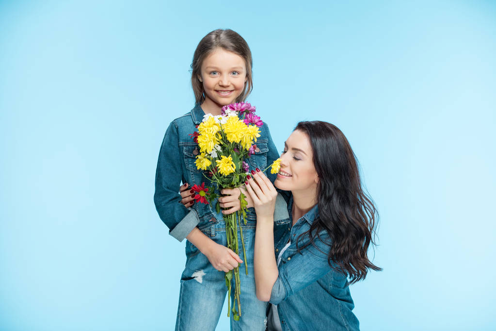 母と娘の花を持って - 写真・画像