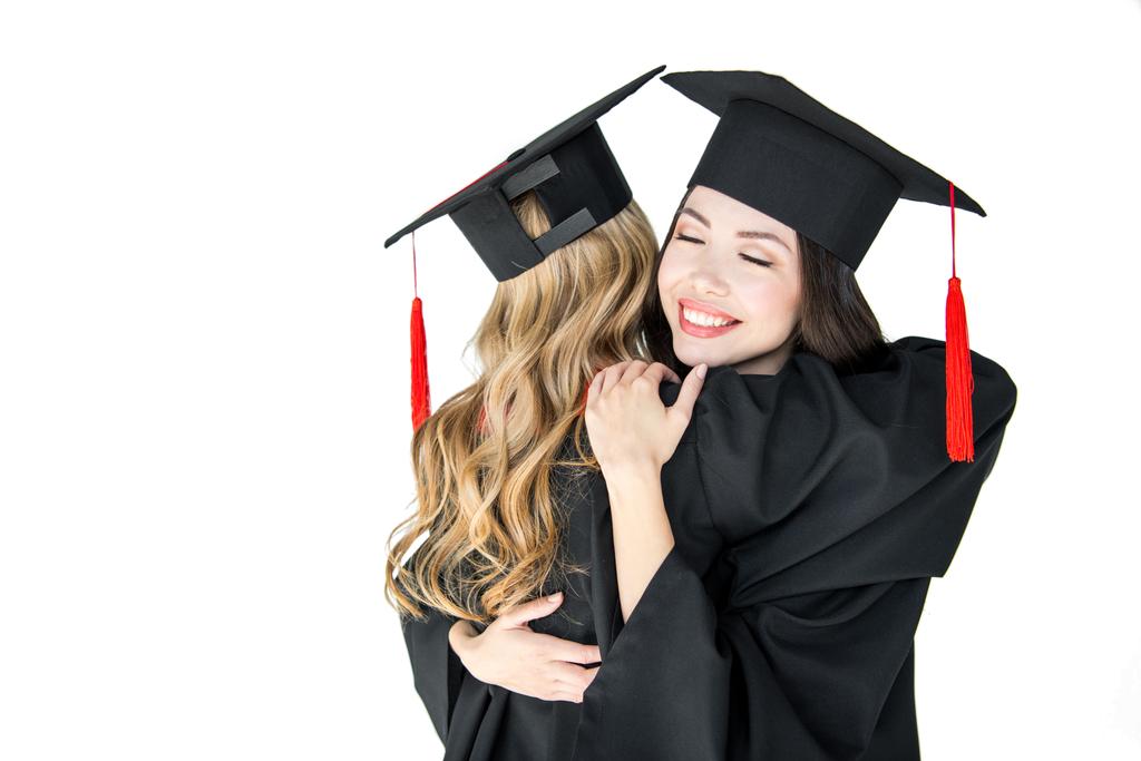 Studenci w graduation czapki przytulanie - Zdjęcie, obraz