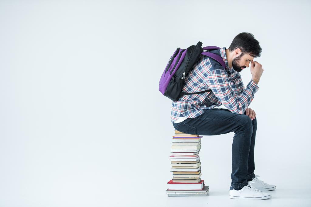 Estudiante sentado en un montón de libros  - Foto, Imagen