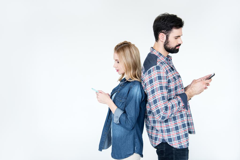 чоловік і жінка використовують смартфони
 - Фото, зображення
