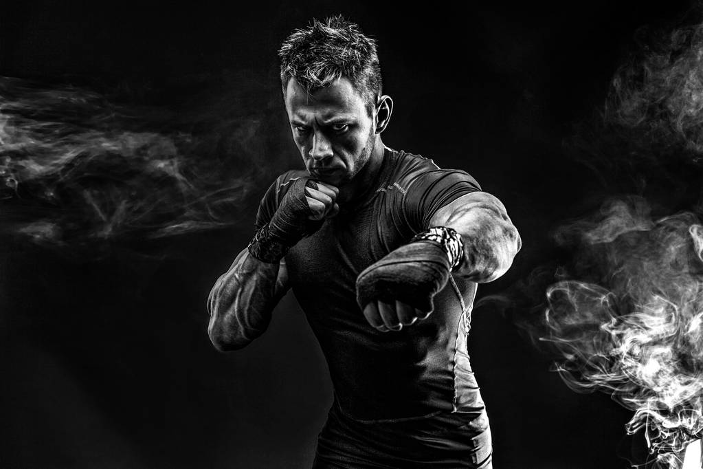 Мускулистый человек, бьющий в дым. Студия
 - Фото, изображение