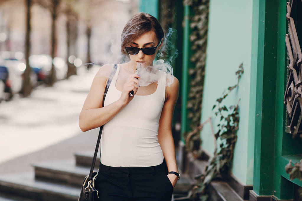 Tyttö sähköisen savukkeen kanssa
 - Valokuva, kuva