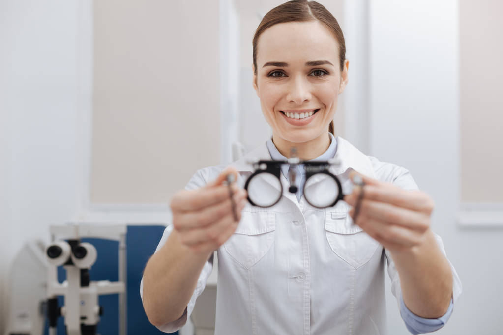 Vrolijke vriendelijke optometrist biedt dat u oog test bril - Foto, afbeelding