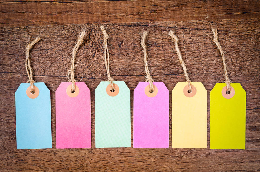 Set di tag appeso vuoto colorato su sfondo di legno
. - Foto, immagini