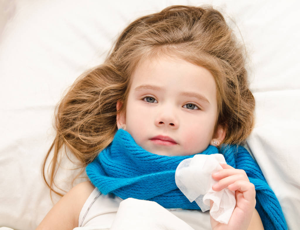 ziek meisje liggend in het bed met sjaal en weefsel  - Foto, afbeelding