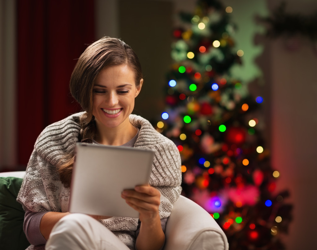 Mujer feliz mirando en la tableta PC en frente del árbol de Navidad
 - Foto, Imagen
