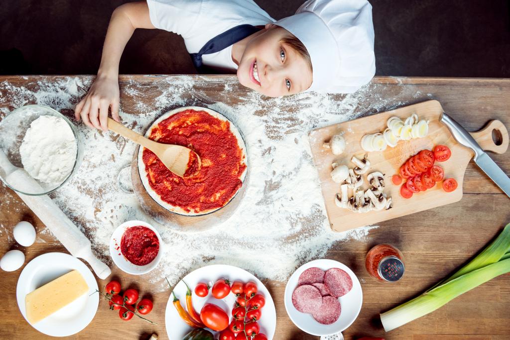 Niño haciendo pizza
 - Foto, imagen