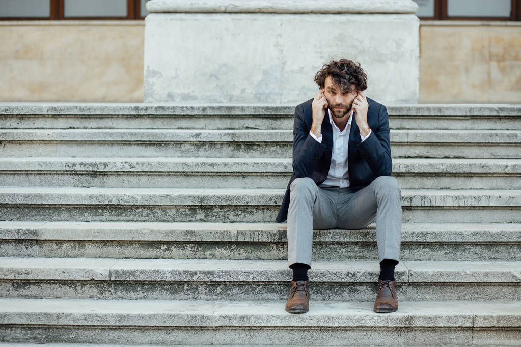 adult and elegant man sitting outside on the stairs - Photo, Image