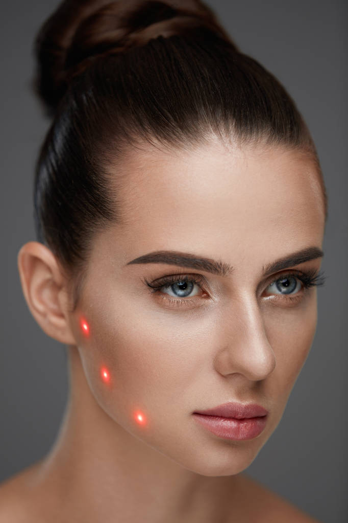 Bella donna con pelle morbida e punti laser rossi sulla pelle
 - Foto, immagini