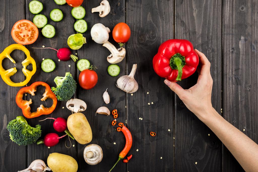Fresh vegetables and hand with pepper  - Photo, Image