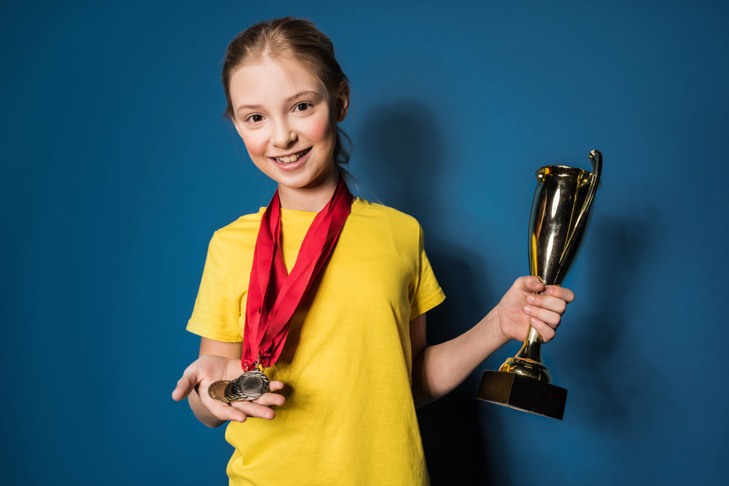 menina com medalhas e troféu
  - Foto, Imagem