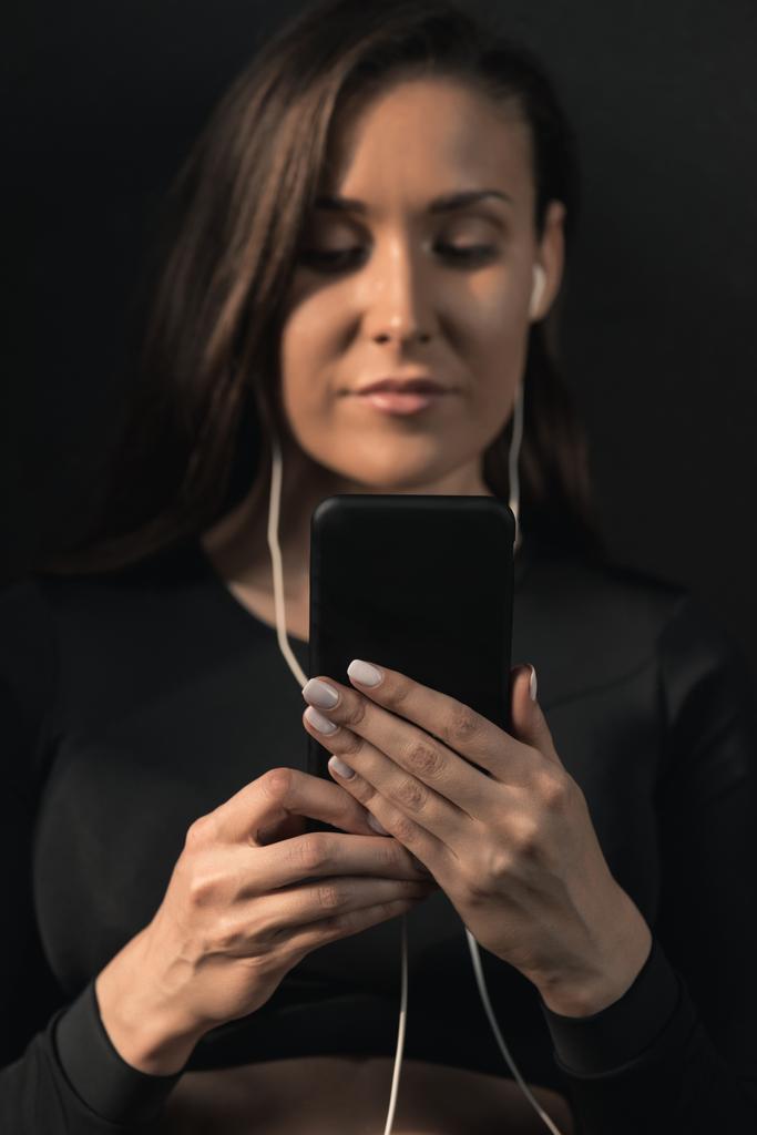 Σπορ γυναίκα με τη χρήση smartphone  - Φωτογραφία, εικόνα