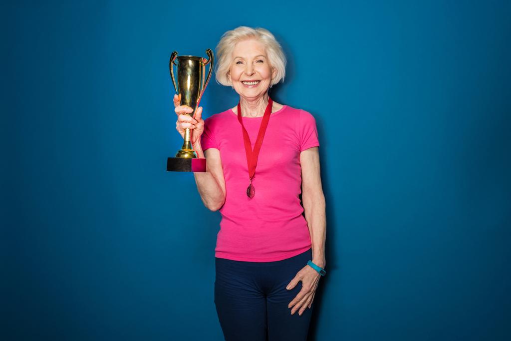 Femme sportive senior tenant un trophée
   - Photo, image