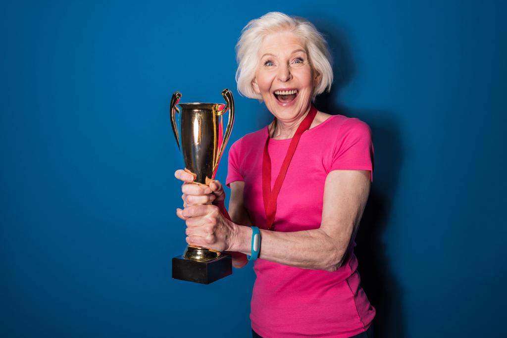 Старшая спортсменка с трофеем
   - Фото, изображение