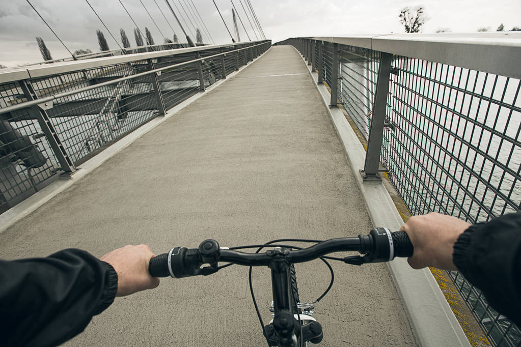 Молодой человек на велосипеде в городском парке через мост
 - Фото, изображение