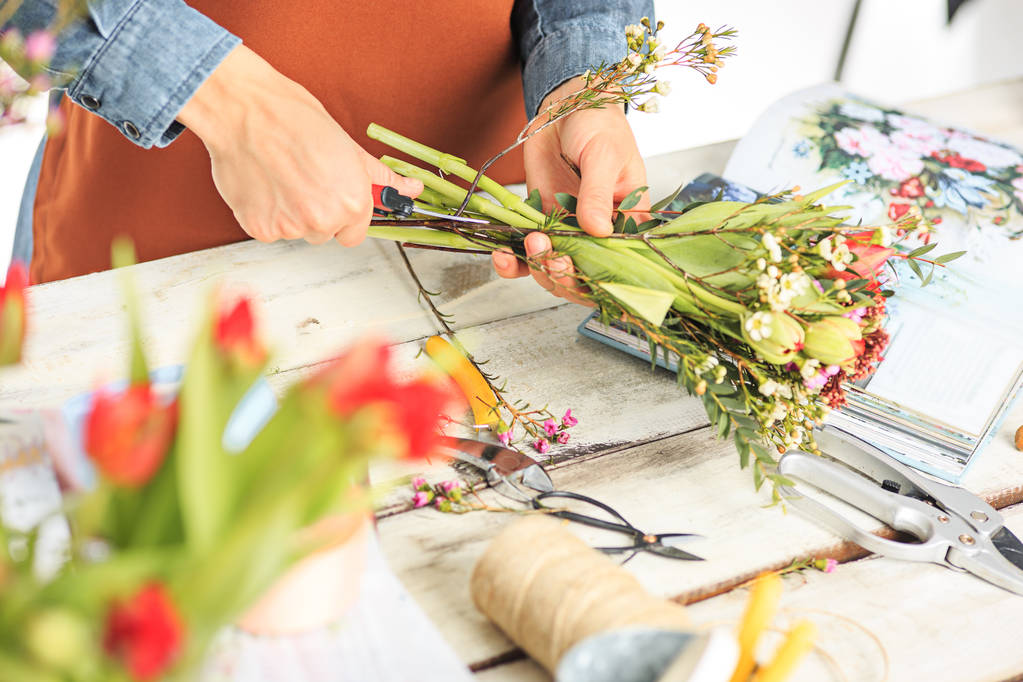Florista en el trabajo: manos femeninas jóvenes haciendo ramo moderno de moda de diferentes flores
 - Foto, imagen