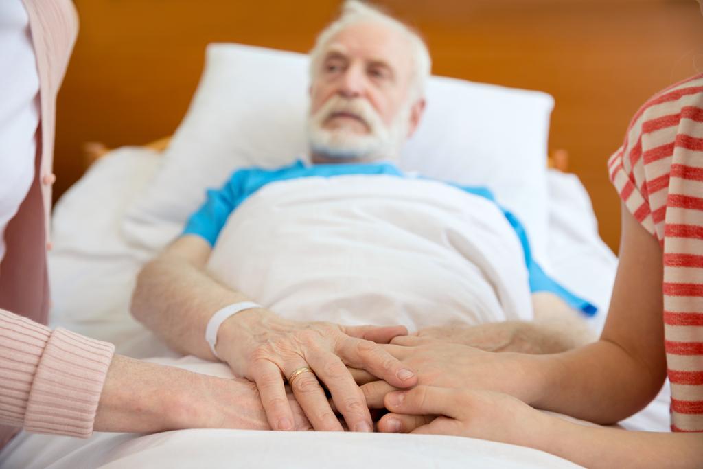 бабуся і дідусь тримають руки з пацієнтом
 - Фото, зображення