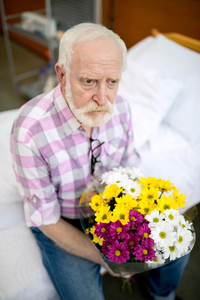 Starší muž s květinami v nemocnici  - Fotografie, Obrázek