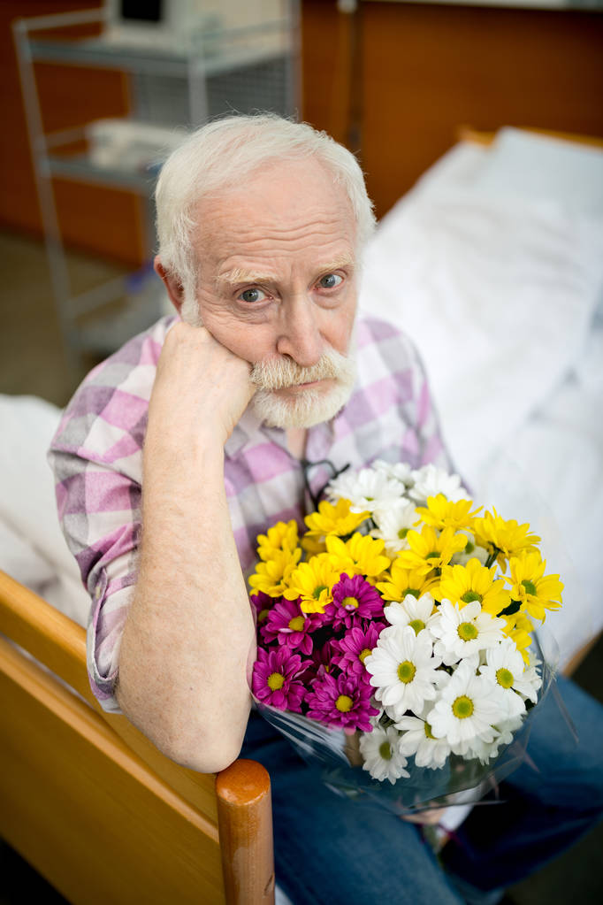 Senior man with flowers in hospital   - Photo, Image