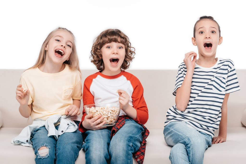 Милые дети на диване с попкорном
 - Фото, изображение