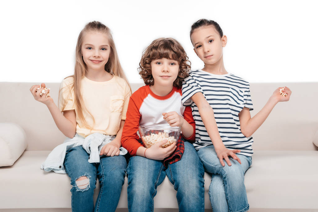 Милі діти на дивані з попкорном
 - Фото, зображення