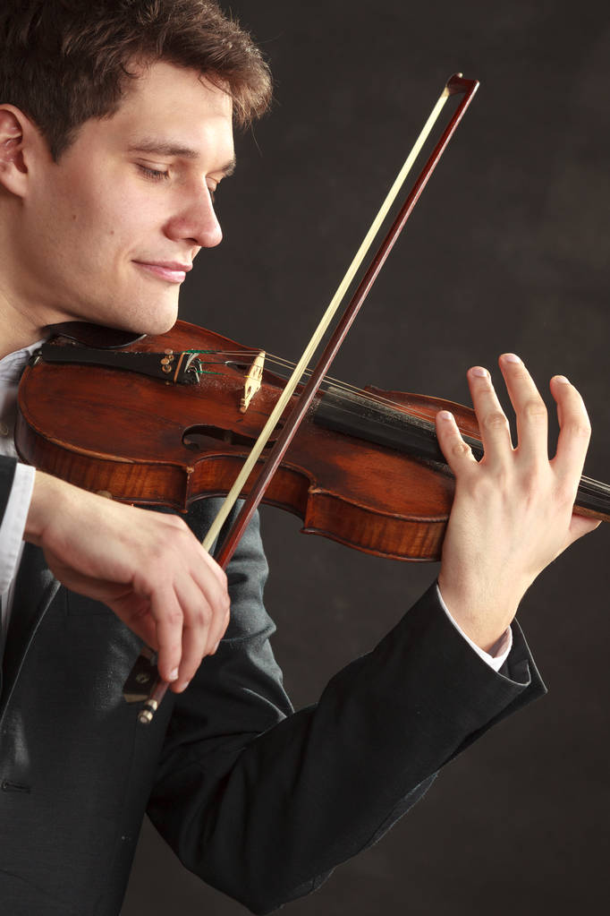Άντρας ντυμένος κομψά παίζει βιολί. - Φωτογραφία, εικόνα