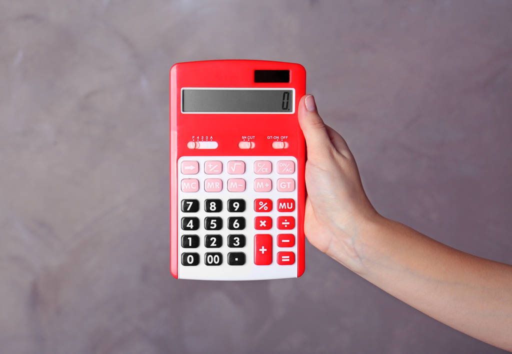Рука тримає червоний калькулятор
 - Фото, зображення