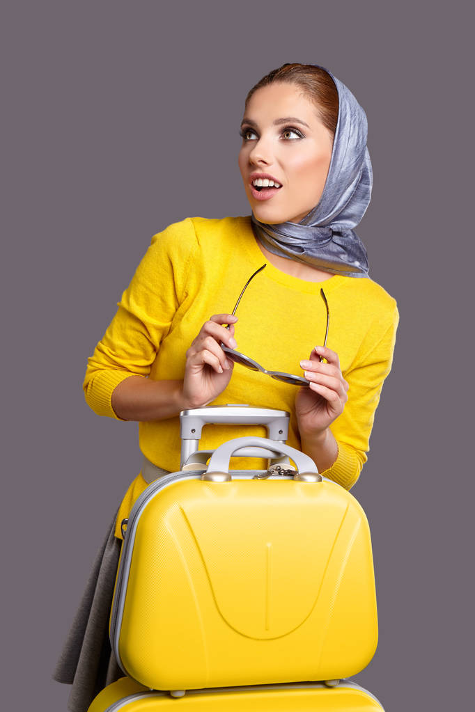 黄色のスーツケースを持つグラマー女性 - 写真・画像