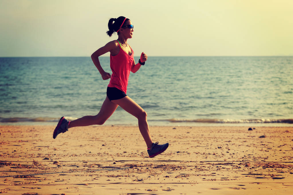 mladá žena běží na písečné pláži  - Fotografie, Obrázek