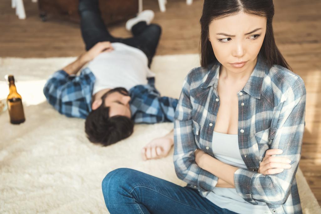 nainen istuu lattialla lähellä humalassa poikaystävä
 - Valokuva, kuva