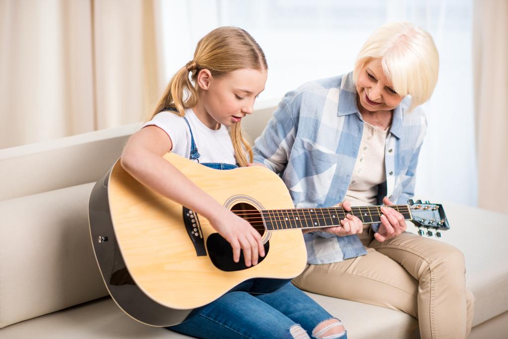 Бабуся і дівчина грати на гітарі - Фото, зображення