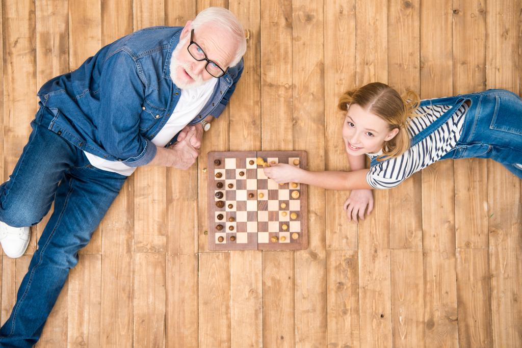 Abuelo y nieta jugando ajedrez
 - Foto, imagen