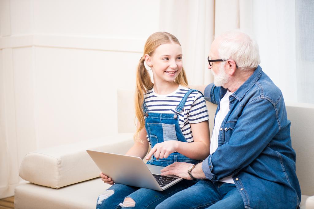 Menina com avô usando laptop
  - Foto, Imagem