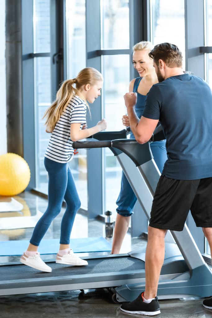Parents supporting daughter workout on treadmill - Photo, Image