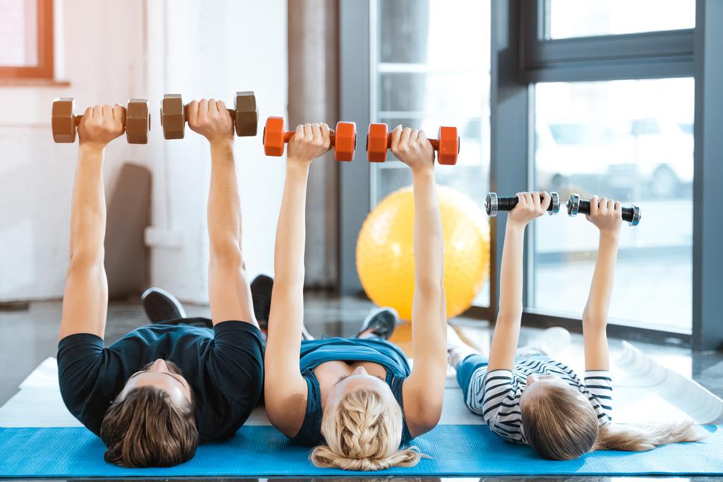 Trainen met halters op fitness-studio en gelukkige familie - Foto, afbeelding