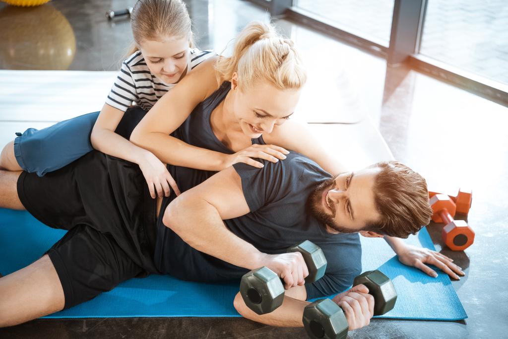 Szczęśliwa rodzina zabawy w siłowni, mężczyzna, trzymając hantle - Zdjęcie, obraz