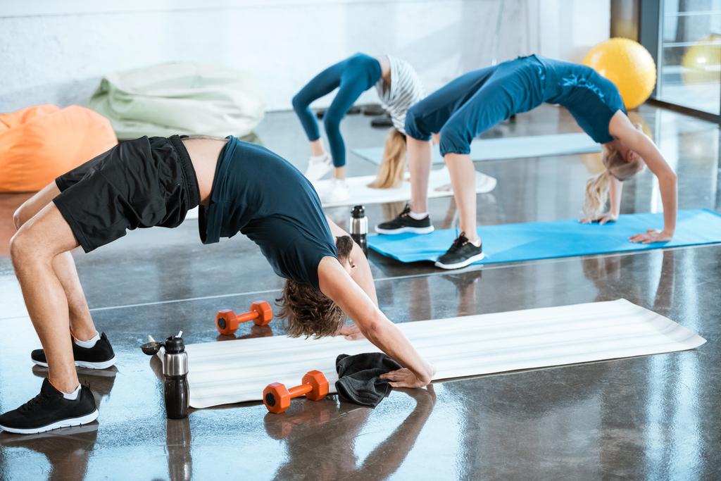 Lidé dělají gymnastika, provádění most představují ve fitness studiu  - Fotografie, Obrázek