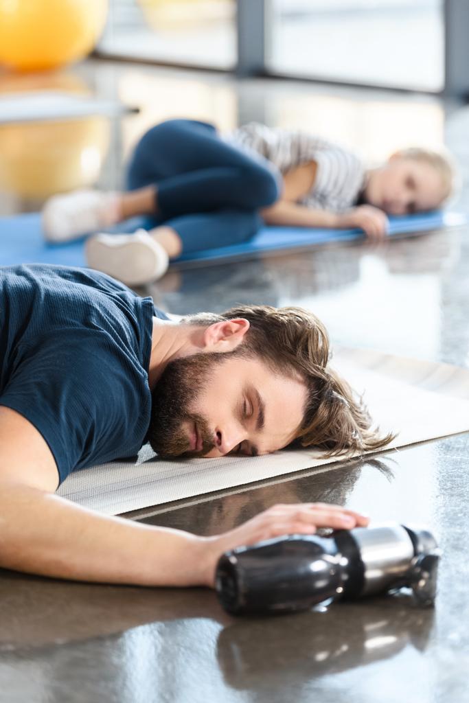 tired sleeping man lying on mat at gym - Photo, Image