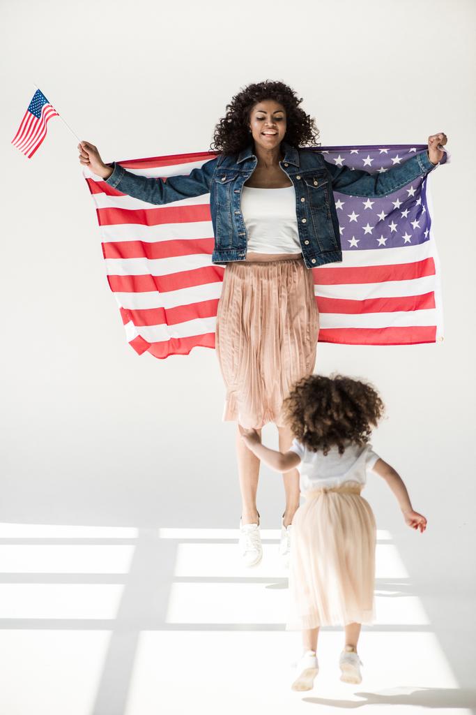 Kobieta i córka skoki z amerykańską flagę  - Zdjęcie, obraz