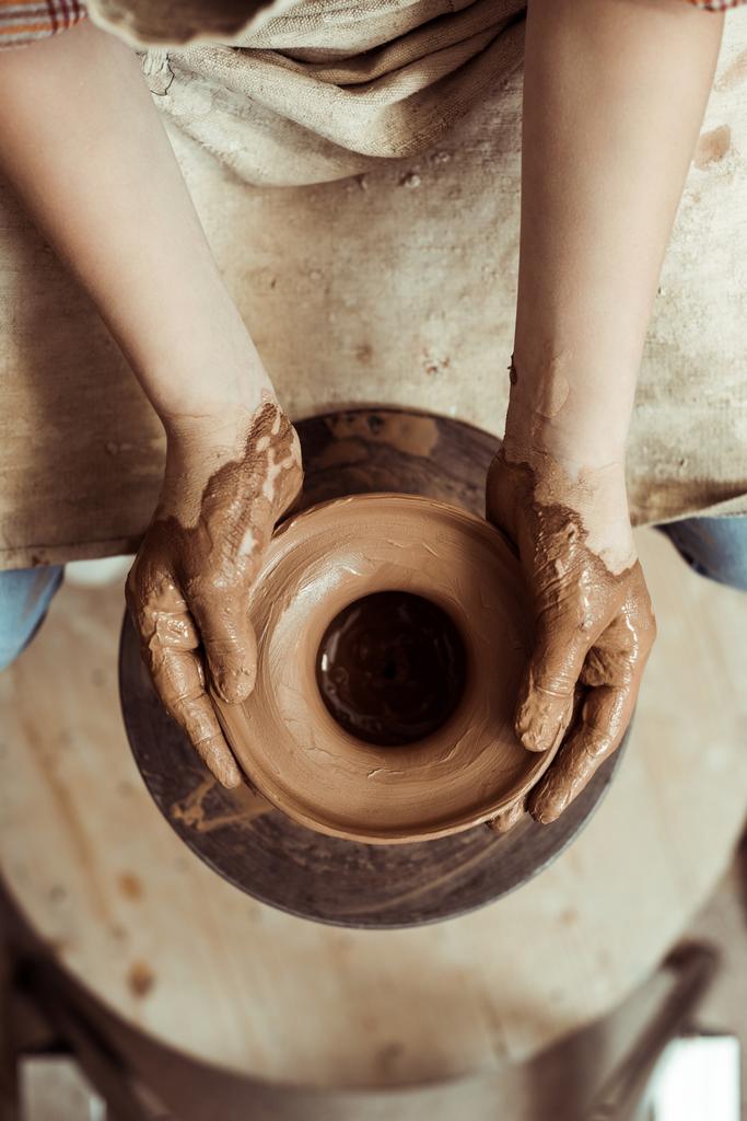 Primo piano delle mani dei bambini che lavorano sulla ruota della ceramica in officina
 - Foto, immagini