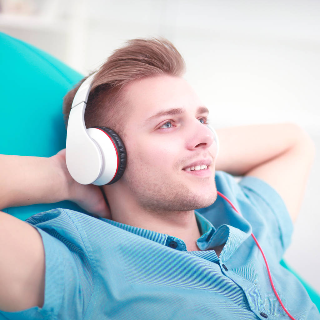 Hombre escuchando música con auriculares en casa
 - Foto, imagen