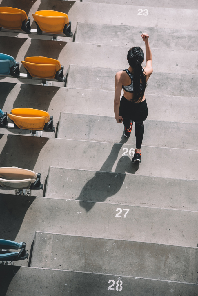 sportswoman running on stadium stairs - Photo, Image