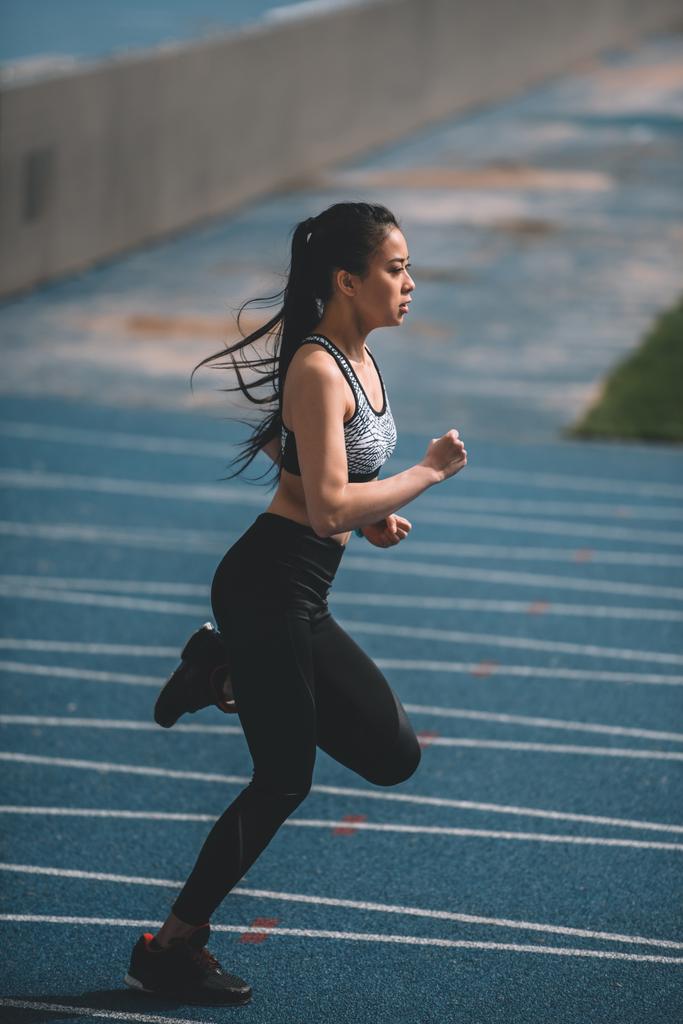 Sportlerin trainiert auf Laufstrecke - Foto, Bild