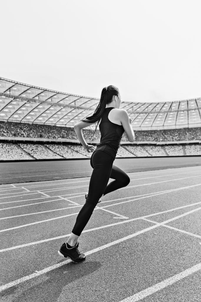 Sportlerin läuft auf Stadion zu  - Foto, Bild