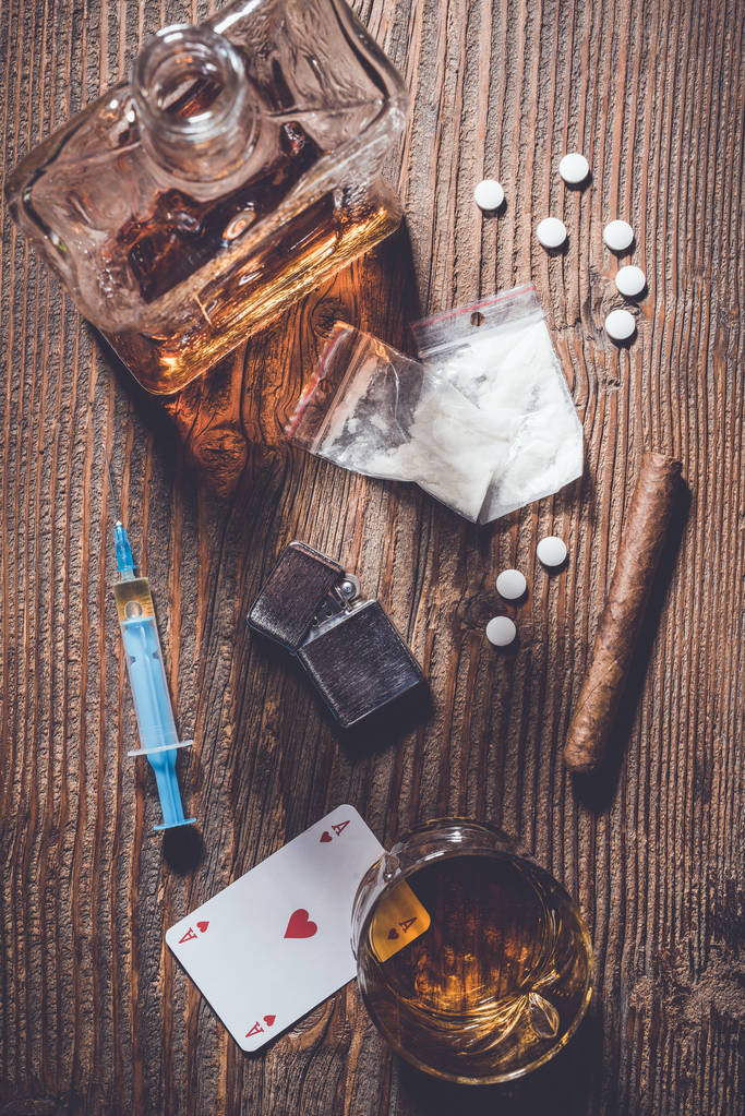 Concepto de adicción. Drogas duras y alcohol en mesa de madera
 - Foto, imagen